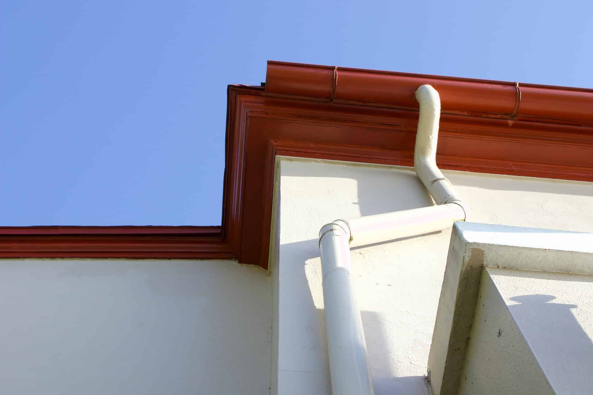 Red gutter with a white wall made by Performance Roofing and Siding in Pontiac, MI