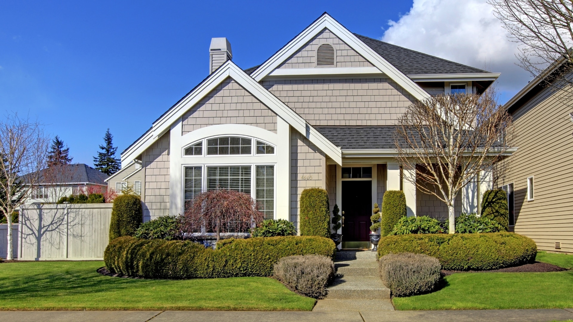 A house with beige siding and a black roof that had a roof repair by Performance Roofing and Siding