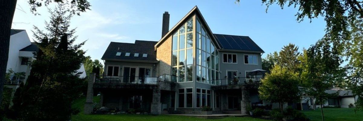 Modern house with black roof and a large glass window by residential roofing contractors in Michigan