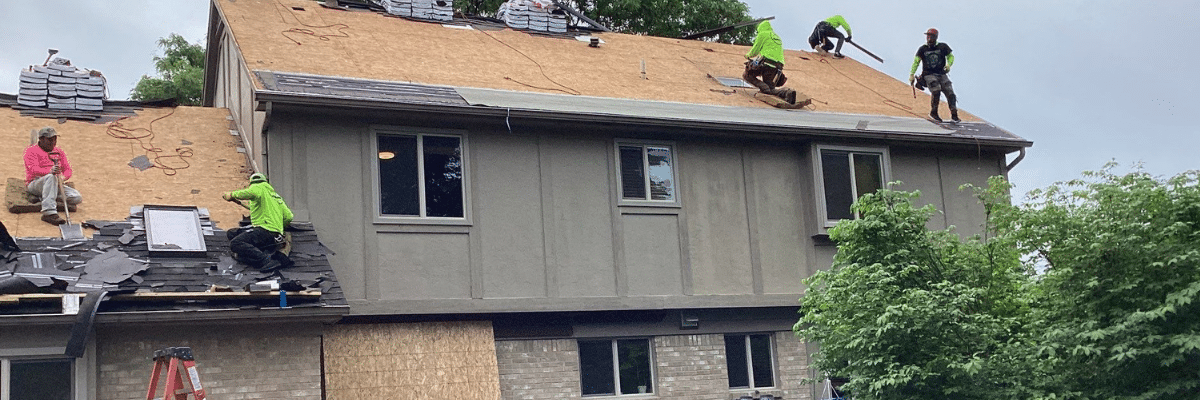 Workers replacing a roof by Performance Roofing & Siding in Pontiac, MI