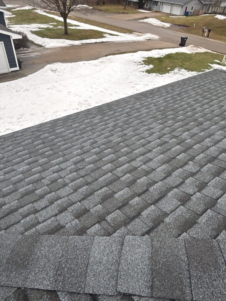 Grey dimensional shingle roof tiles during a roof inspection by Performance Roofing & Exteriors