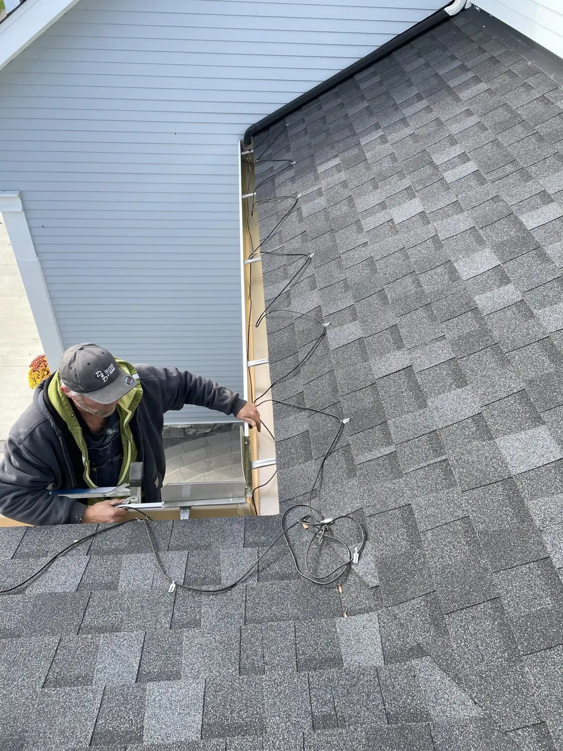 A contractor from Performance Roofing and Siding installs wiring for a new roofing and siding project.