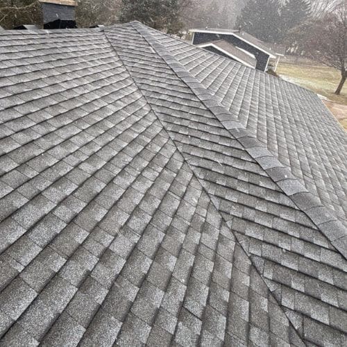 A roof with old, gray asphalt shingles shows signs of wear before replacement.
