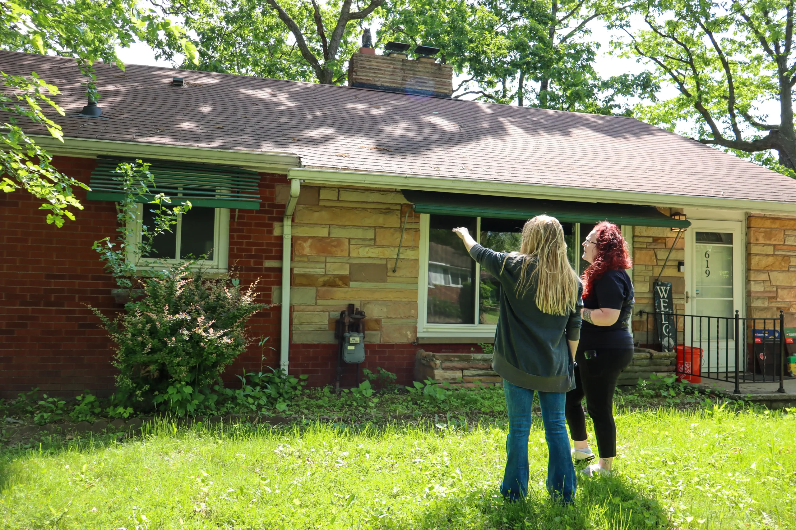 Performance Roofing & Siding specialist and homeowner evaluating the condition of a residential roof and exterior during a thorough roof inspection in Pontiac, MI.