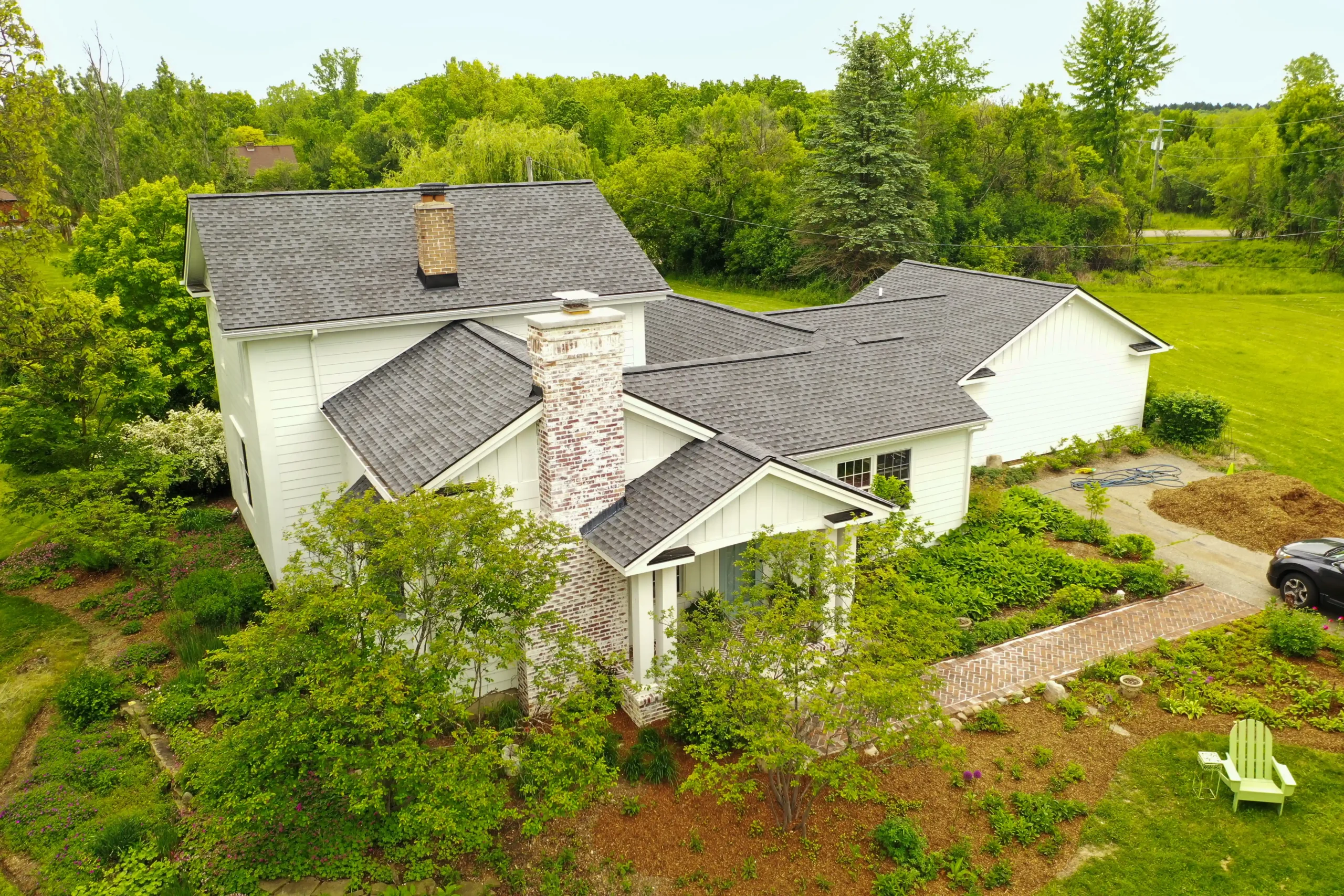 Single-story suburban home with a well-maintained roof and lush landscaping, representing residential roofing inspection services by Performance Roofing & Siding in Pontiac, MI.