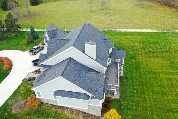 Overhead image of a large home displaying new roofing and siding installation, completed by Performance Roofing & Siding for LP General Grand Rapids